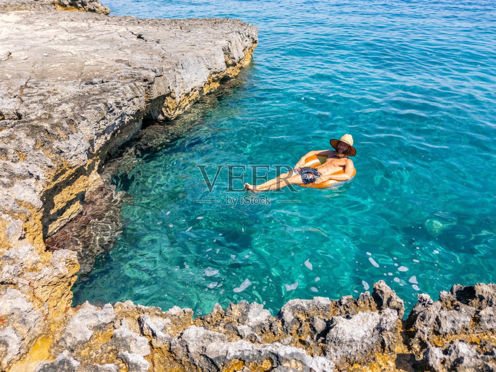 游客在清澈的水中放松地漂浮在充气筒上照片摄影图片