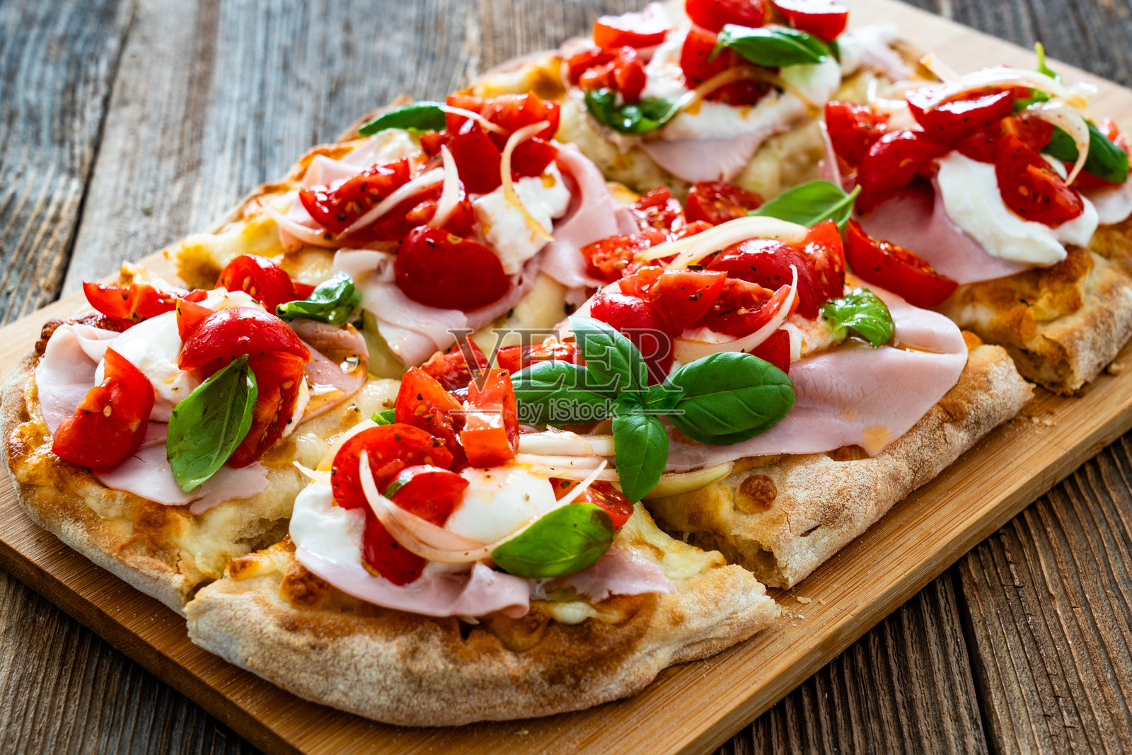 罗马披萨，上面有熟火腿、布拉塔奶酪和蔬菜，放在木桌上照片摄影图片