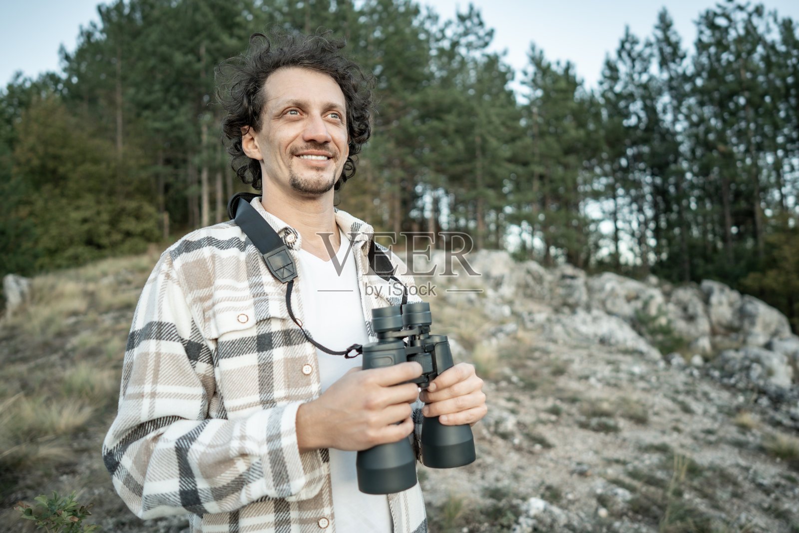 在森林和岩石间的户外，准备冒险的男人手持望远镜照片摄影图片