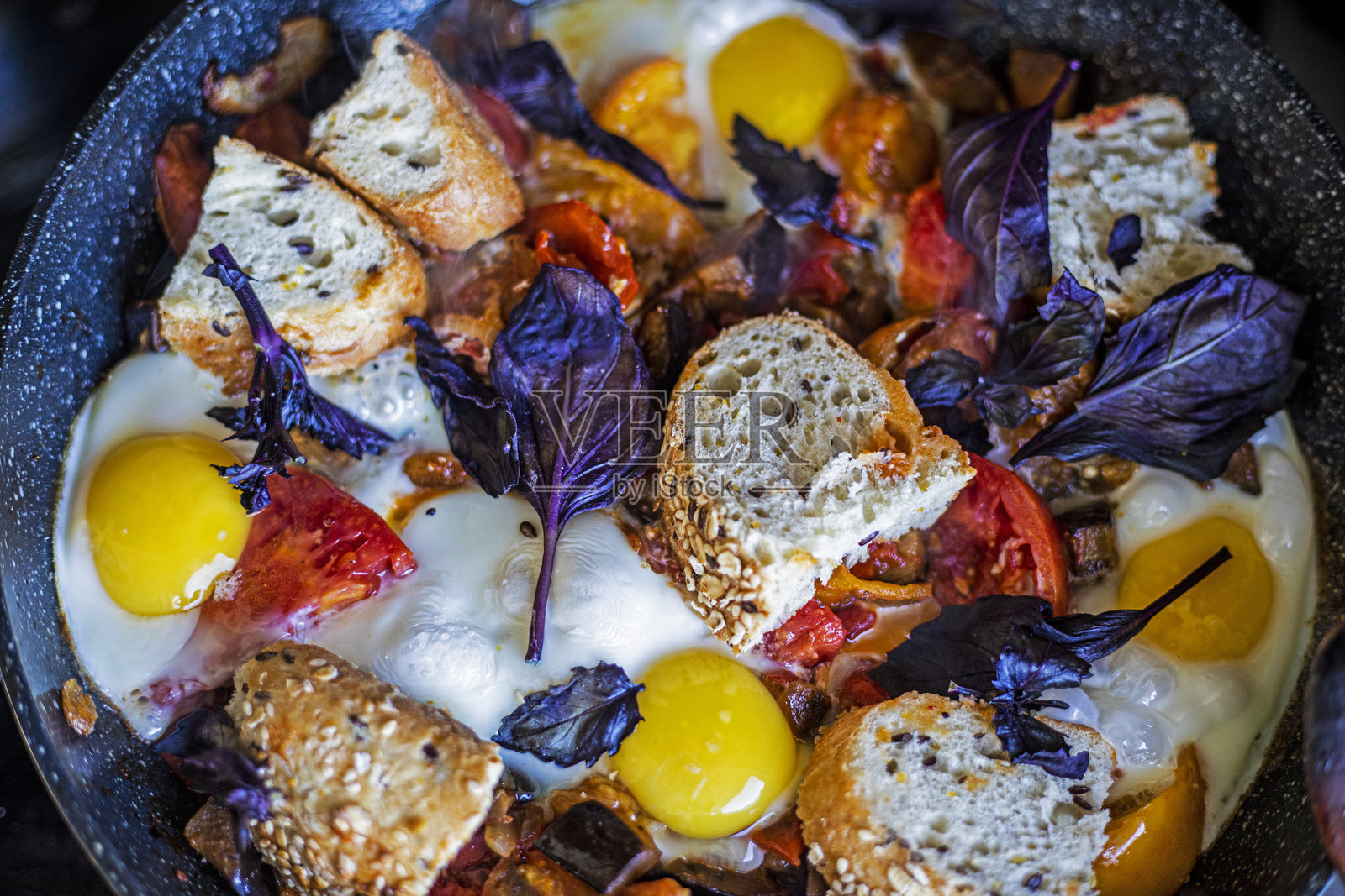 煎锅中的番茄炒蛋、面包和罗勒照片摄影图片