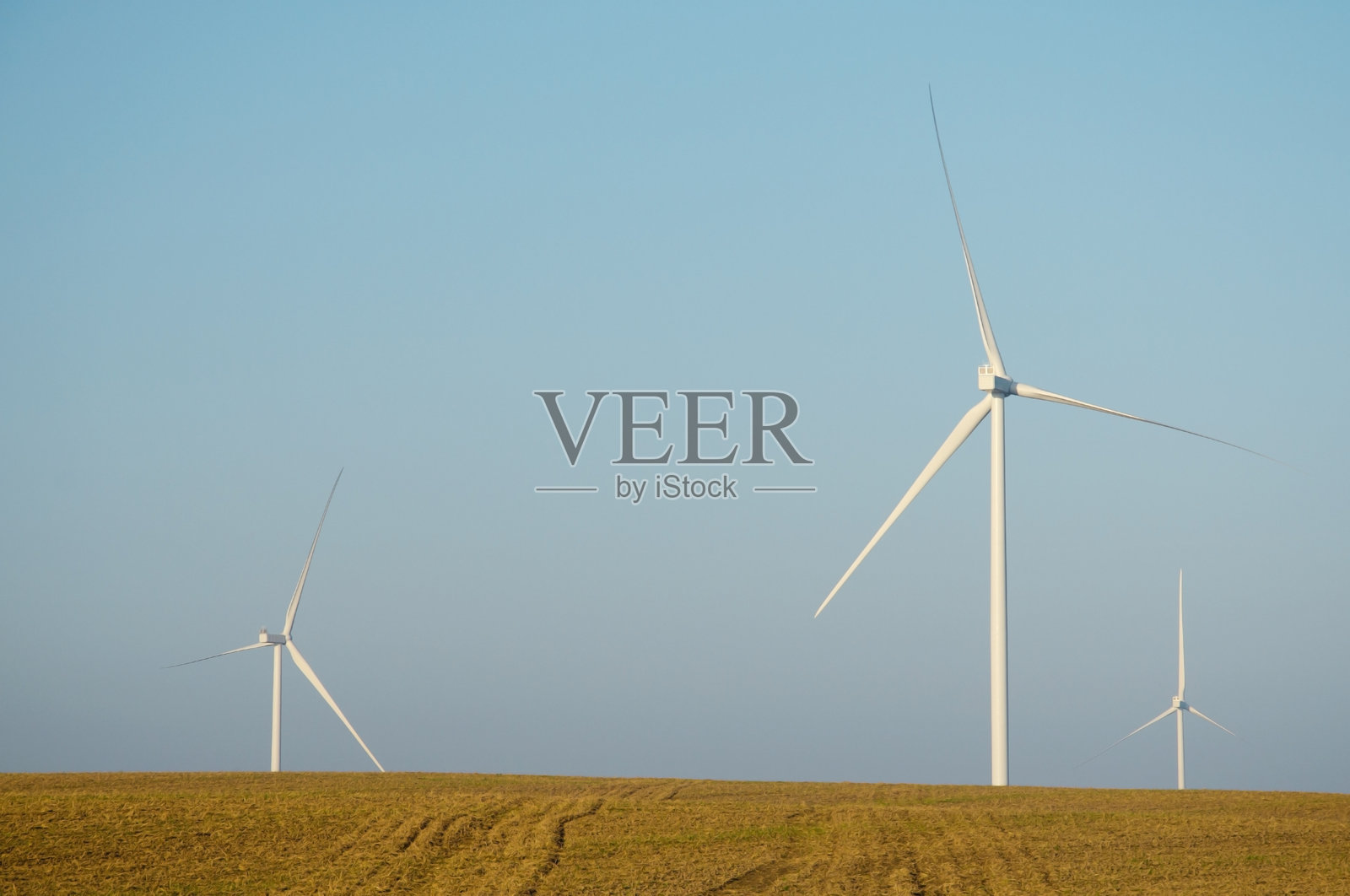 可再生能源。日出时分秋日田野里的风力发电场。建造风力涡轮机。风力涡轮机基座。照片摄影图片