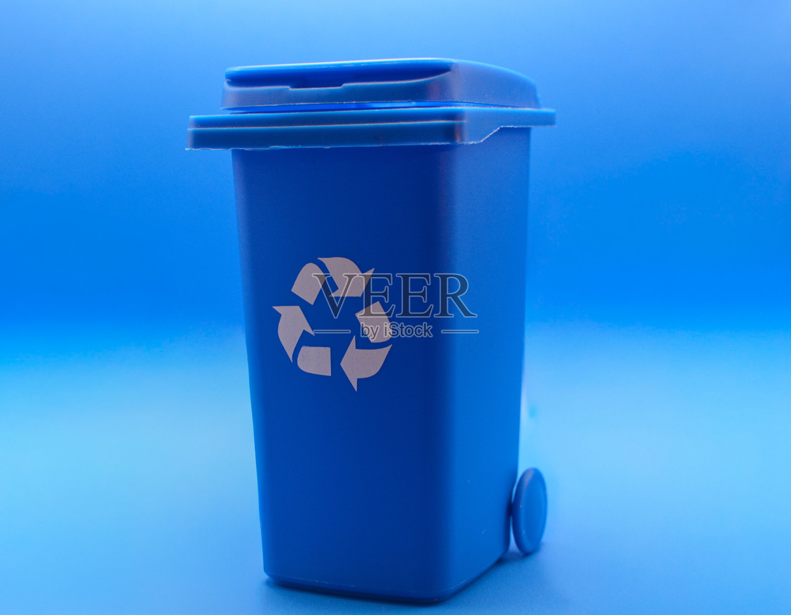 蓝色的回收箱在蓝色的背景上照片摄影图片