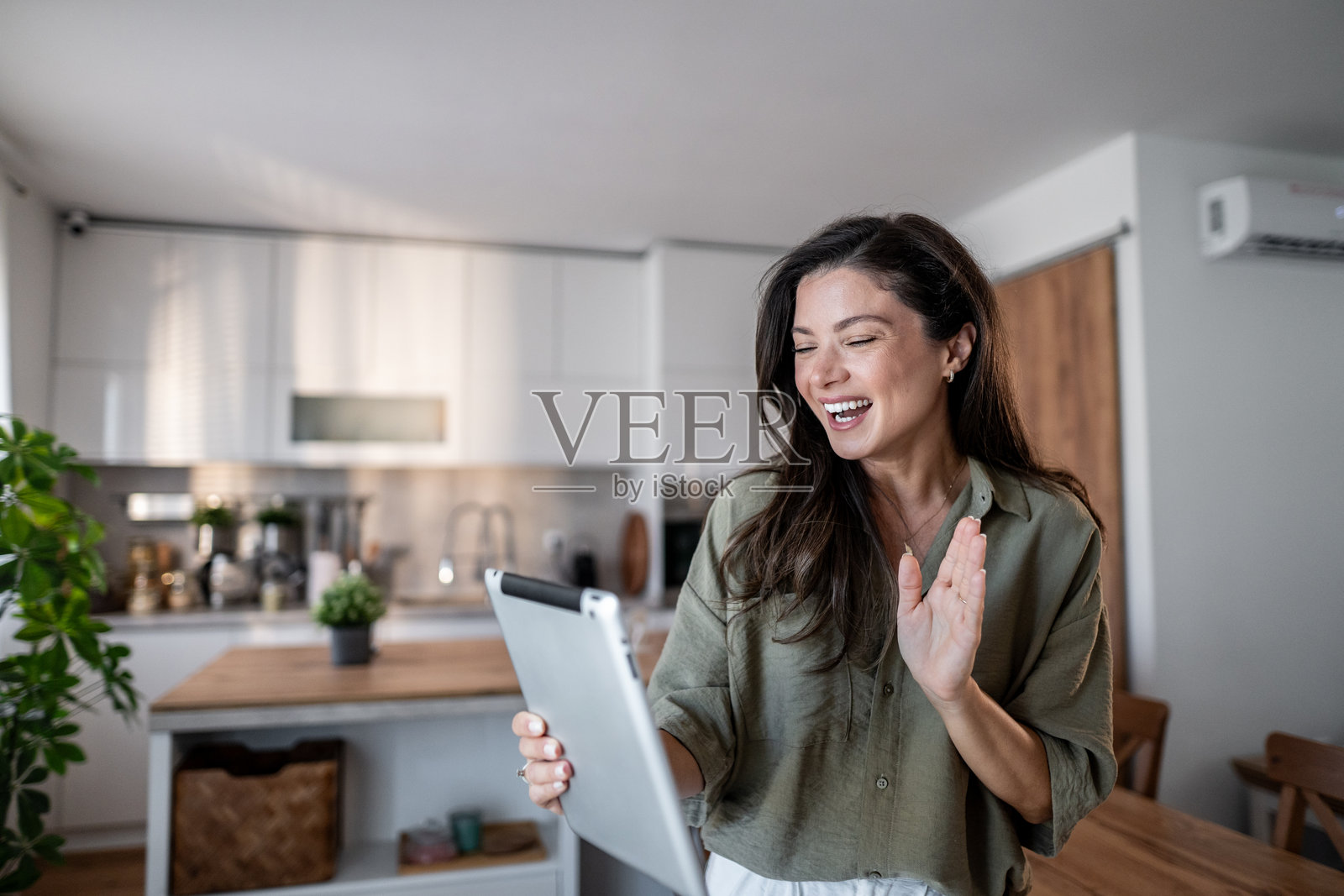 女子在家中厨房使用平板电脑进行视频通话照片摄影图片