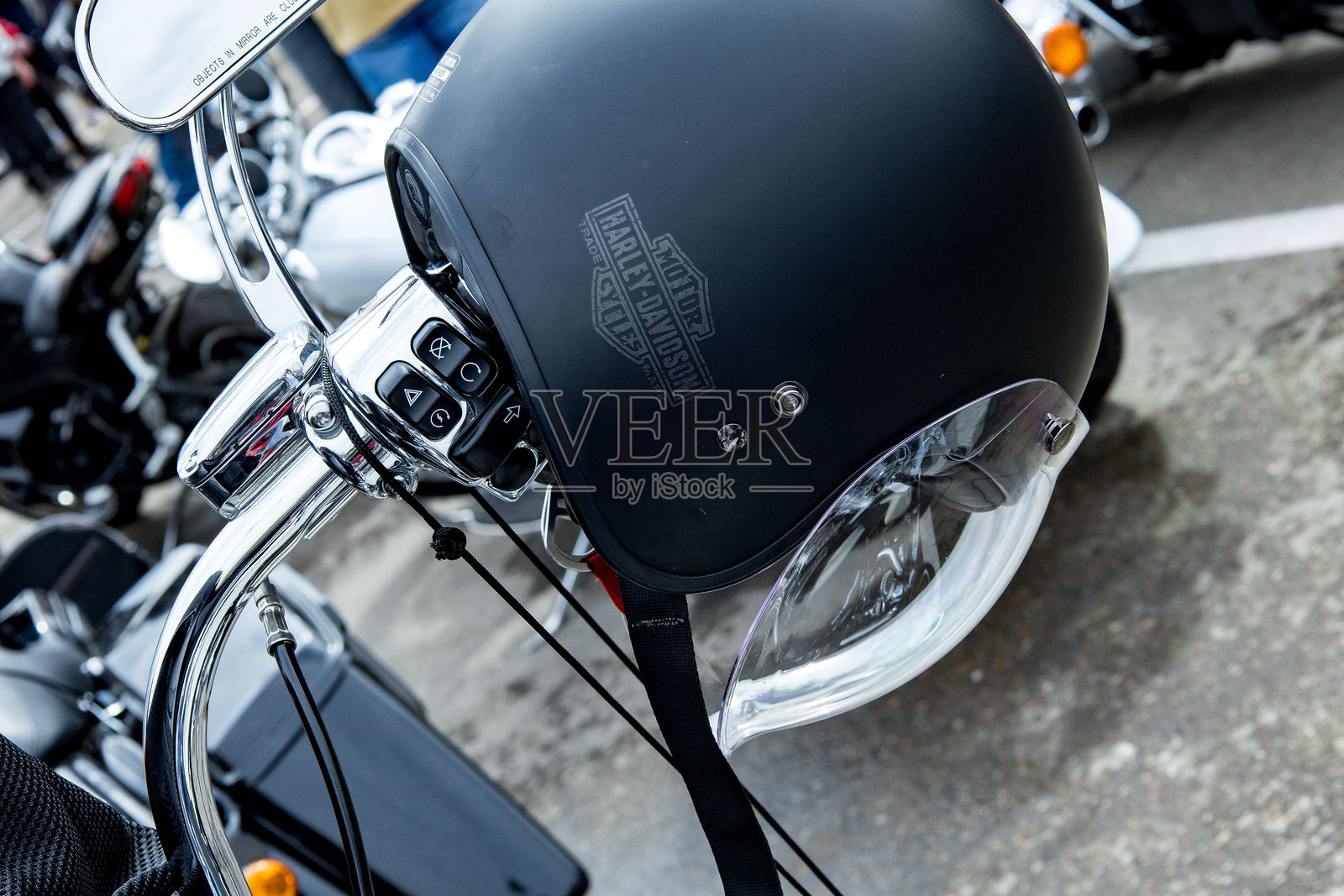 摩托车头盔放在车把上,在户外活动中,展出了各种自行车品牌和车手,他们展示了对摩托车的热情。照片摄影图片