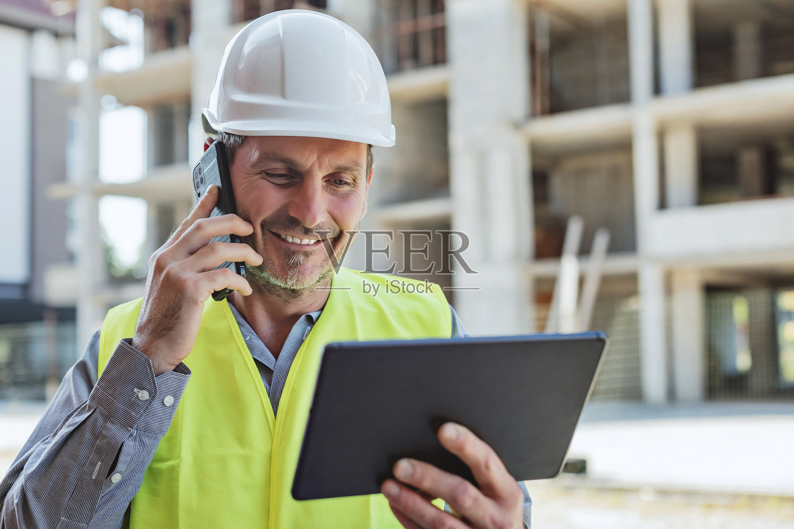 Construction manager coordinating tasks with digital tools照片摄影图片