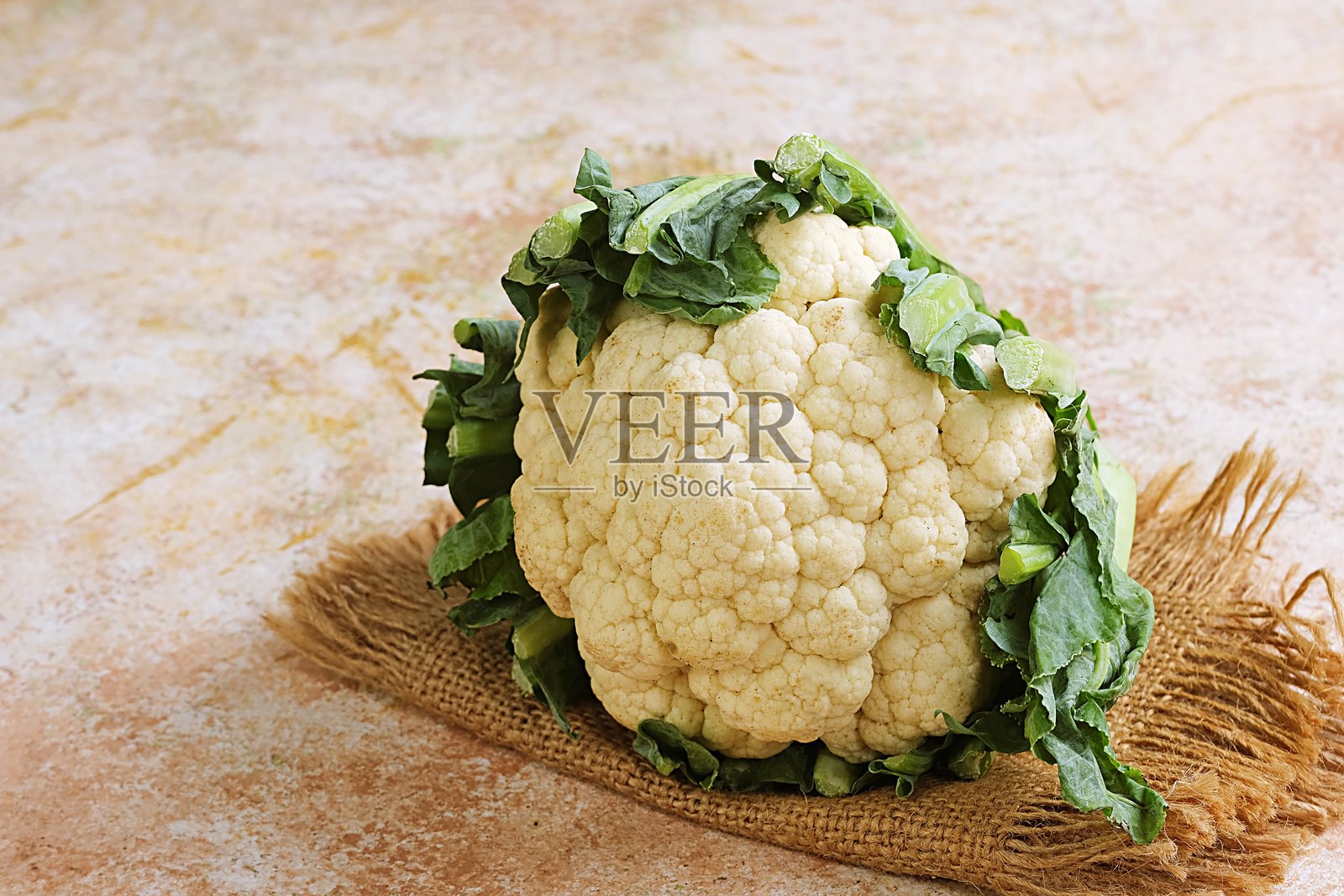 带有叶子的有机花椰菜放在粗麻布上照片摄影图片