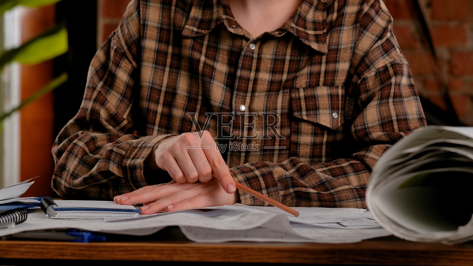 桌边学习者，周围有笔记本和文件照片摄影图片