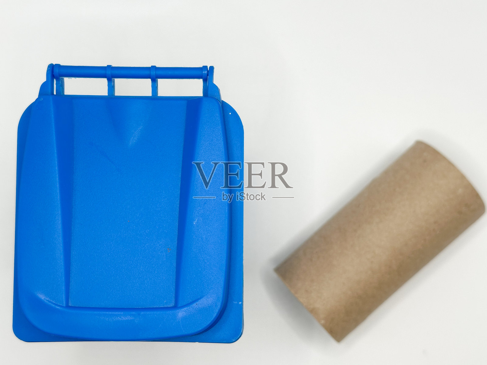 白色背景上的蓝色回收箱和纸板管照片摄影图片