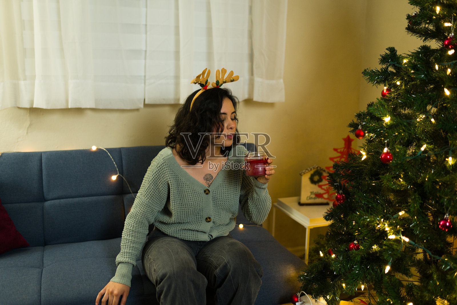 女人在家中圣诞庆祝活动结束时吹灭蜡烛照片摄影图片