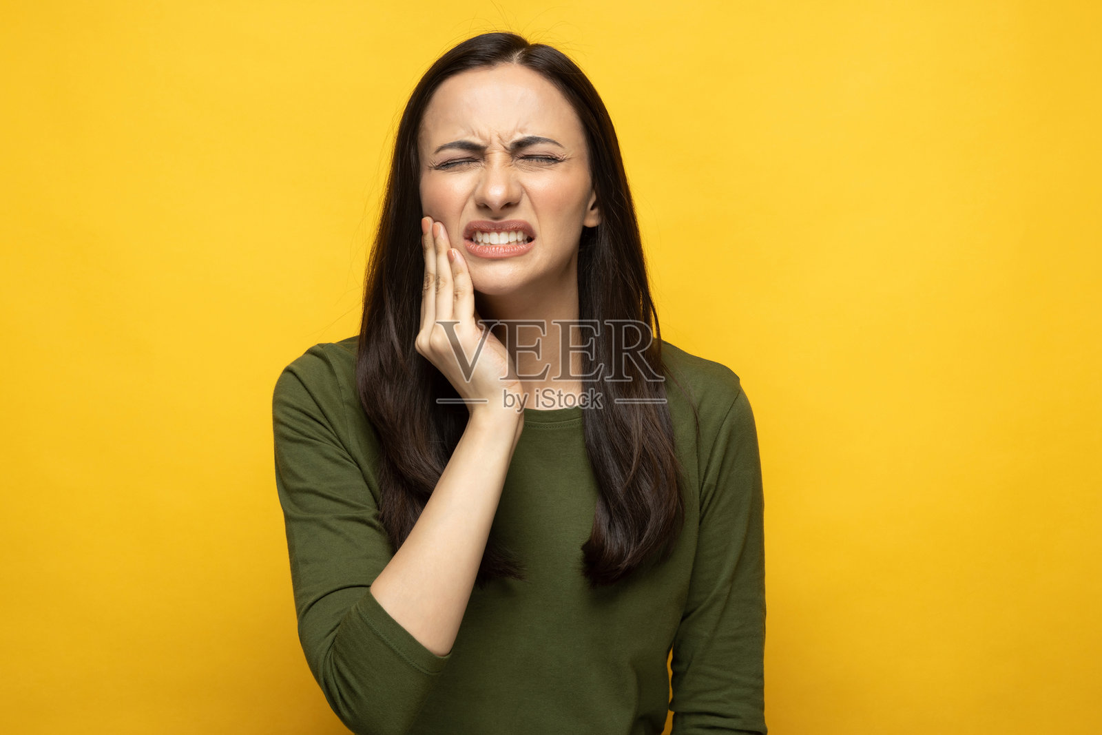 身穿绿色T恤的年轻女子肖像，孤立在黄色背景上照片摄影图片