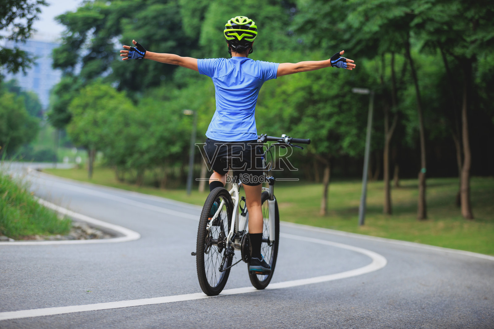 女人在公园里解放双手骑行照片摄影图片