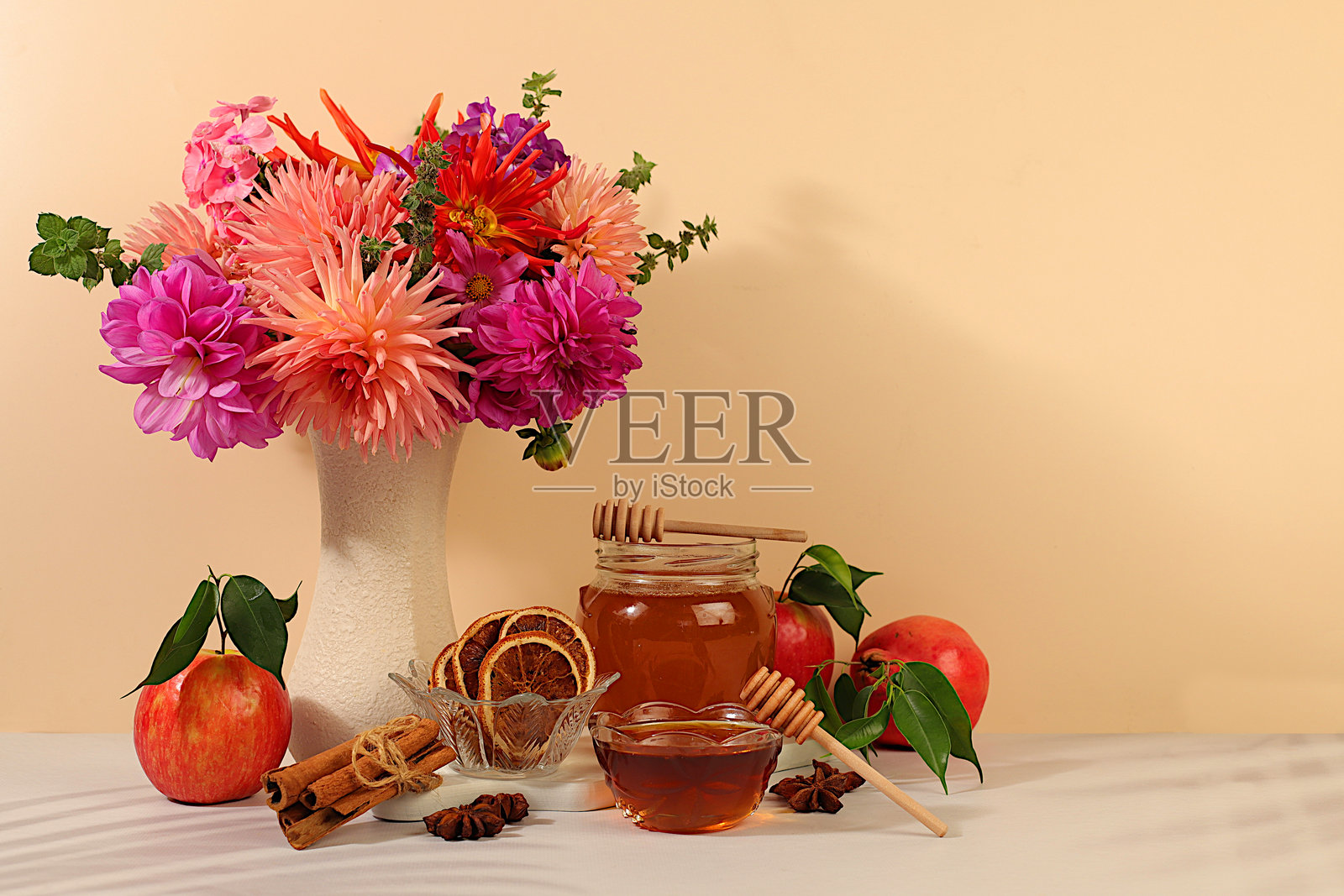 秋季横幅，花瓶里插着美丽的 dahlia（大丽花）花束，背景优雅，摆放着蜂蜜、苹果、石榴、肉桂和八角，秋季问候和感恩节概念，舒适的氛围构图和广告卡片照片摄影图片