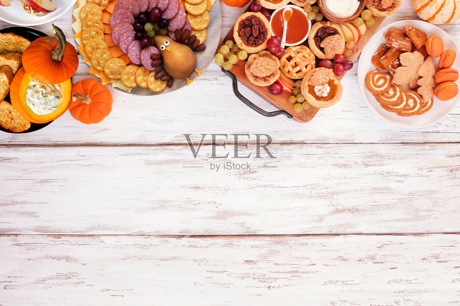感恩节开胃菜、甜点和零食拼盘。白色木质背景上的俯视顶部边框。照片摄影图片