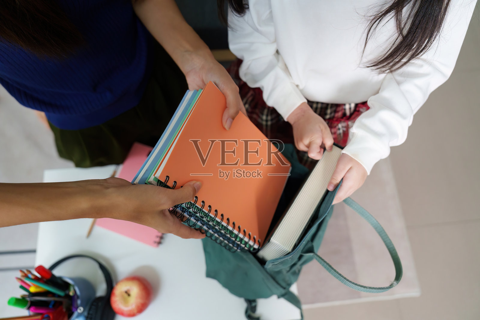 分享笔记本准备上学的双手，旁边有苹果照片摄影图片