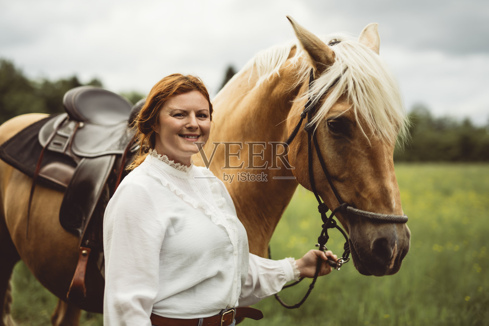一名女子戴着牛仔帽在开阔的田野里骑马照片摄影图片