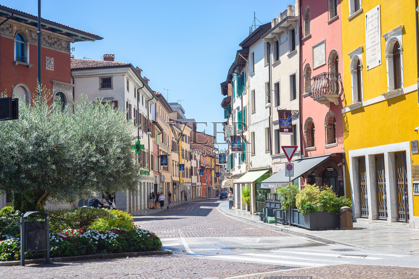 色彩斑斓的欧洲街景，有明亮的建筑、咖啡馆和鹅卵石路。照片摄影图片