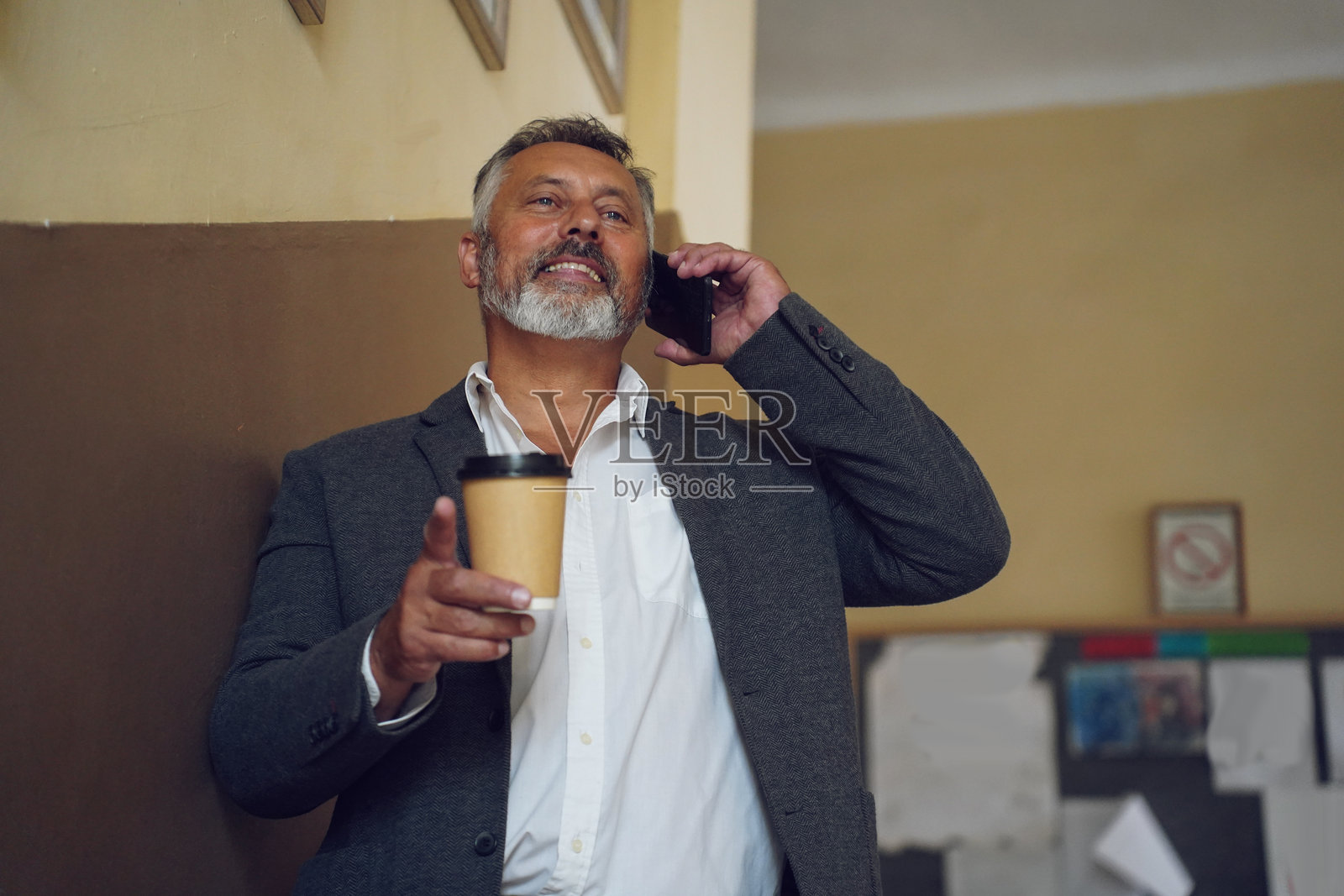 年长的老师在学校走廊享受咖啡休息时间照片摄影图片