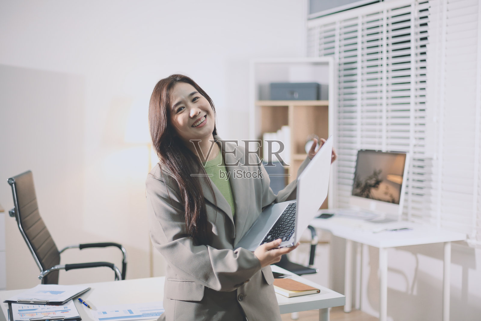 办公室里站立的年轻西班牙裔职业女性肖像。快乐的女公司高管、微笑的女商人、企业家、企业领导者、经理看着镜头使用平板电脑。照片摄影图片