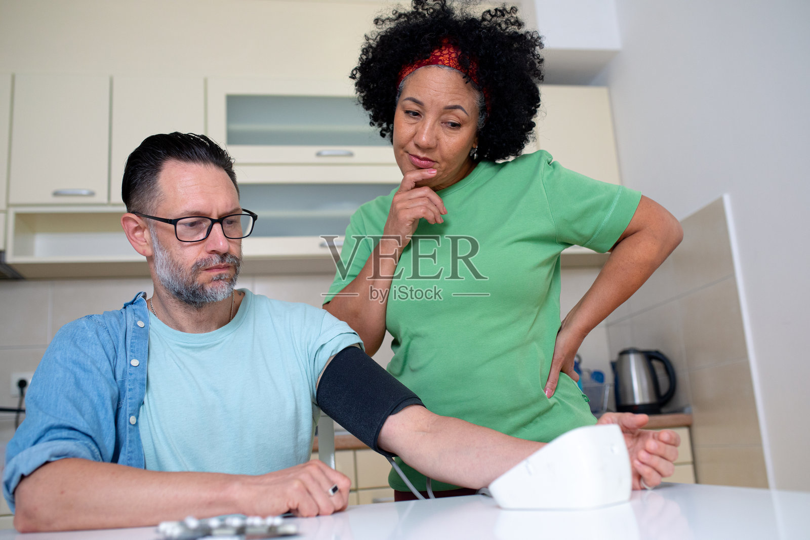 一对夫妇在家中检查血压，担心高血压 - 库存照片照片摄影图片