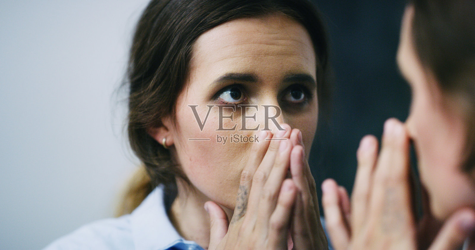 精神分裂、分离危机和身份认同混乱的女性，镜中映照出思索的她，焦虑不安，如同精神病患者，面临人格分裂、精神疾病和内心挣扎。照片摄影图片