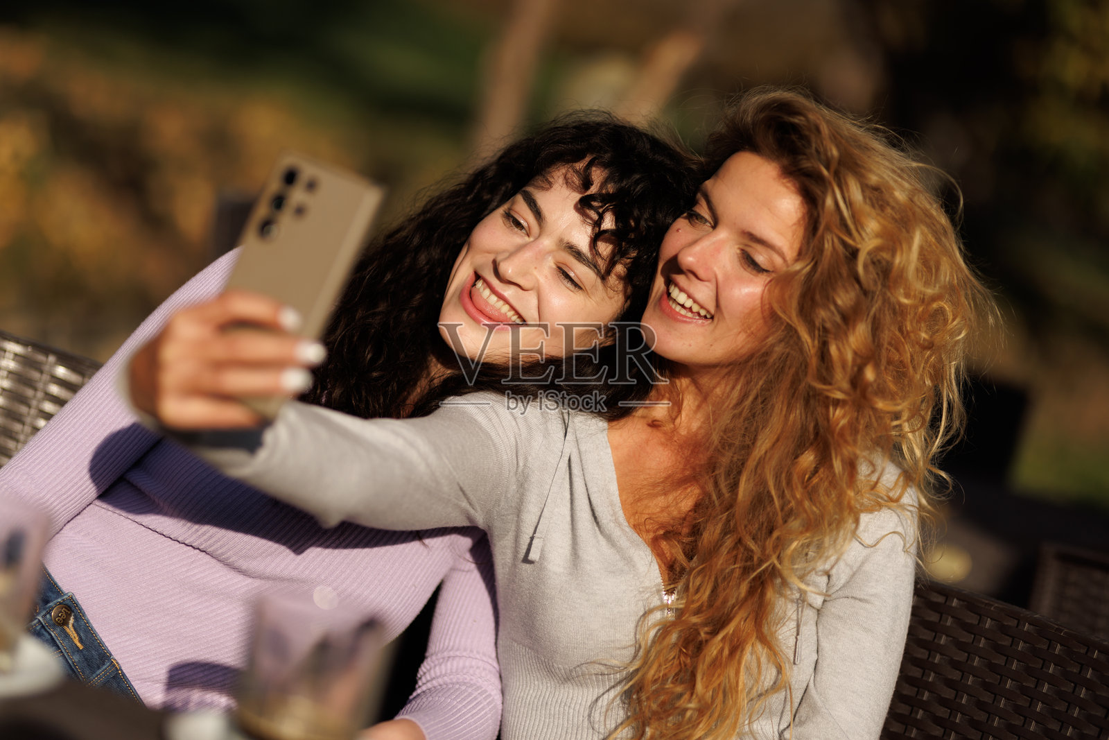 在阳光明媚的午后，朋友们在温馨的环境中举杯畅饮，共同捕捉欢乐瞬间。照片摄影图片