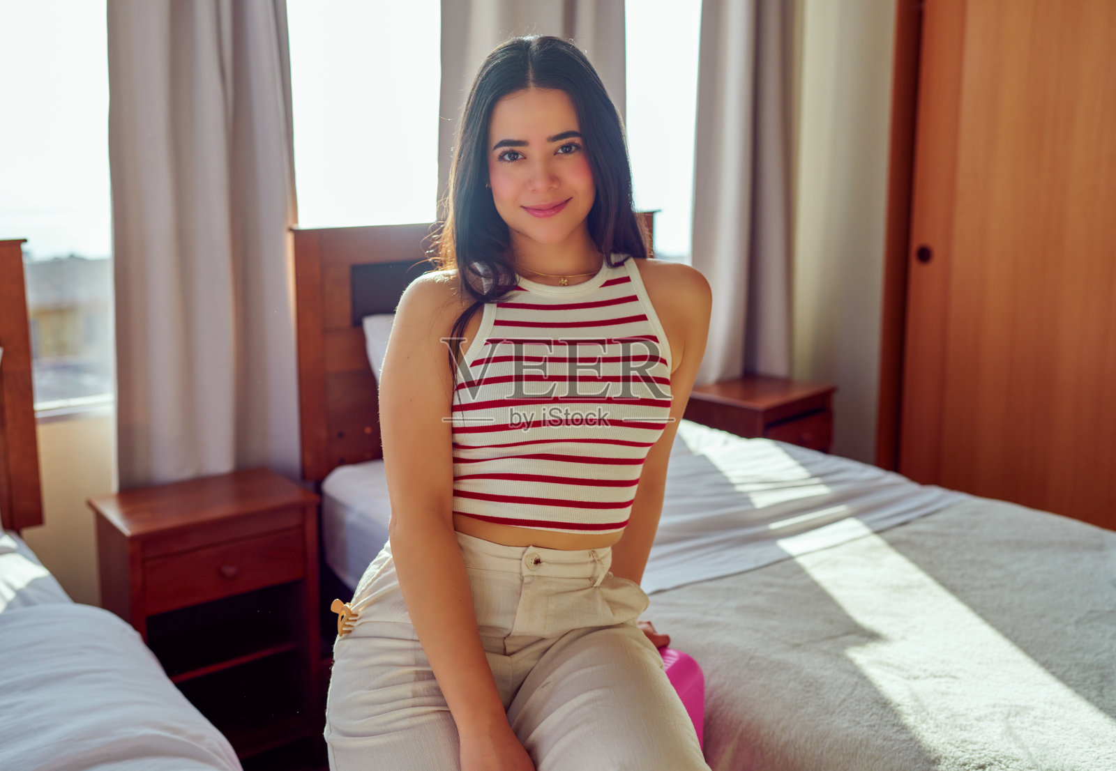 年轻的拉丁裔女性抵达酒店房间后放松休息照片摄影图片