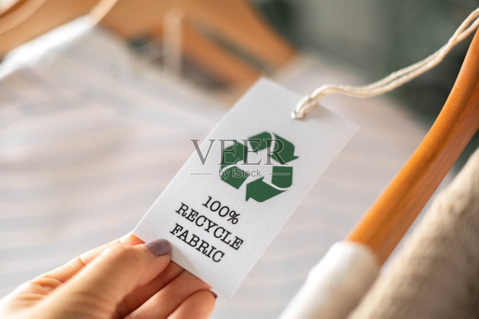 环保服装标签，衣服架上带有可回收面料标志，代表可持续时尚。照片摄影图片