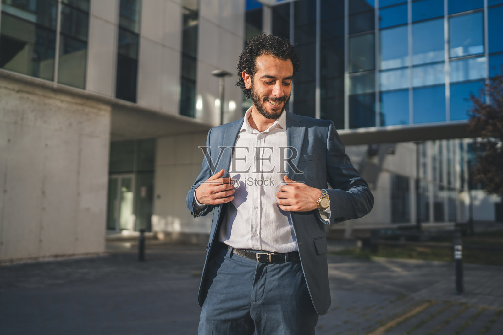 身着优雅西装的商务人士在城市背景下整理着装照片摄影图片