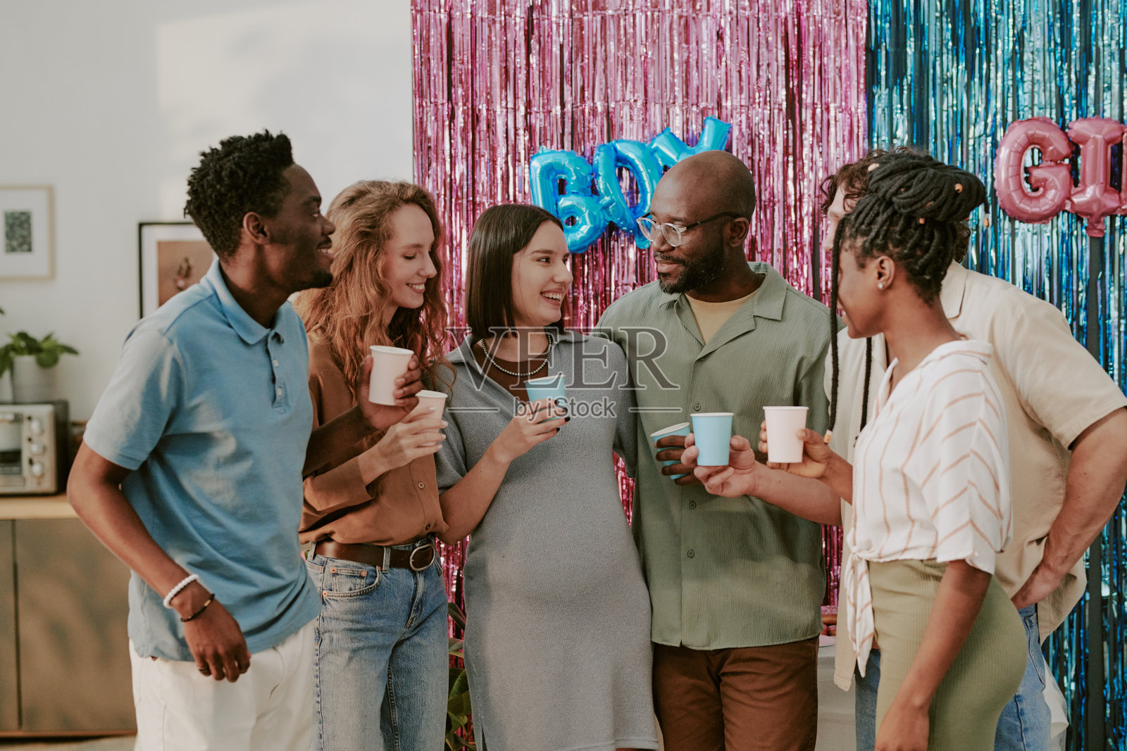 一群年轻的多元化成人正在婴儿派对上共同庆祝照片摄影图片