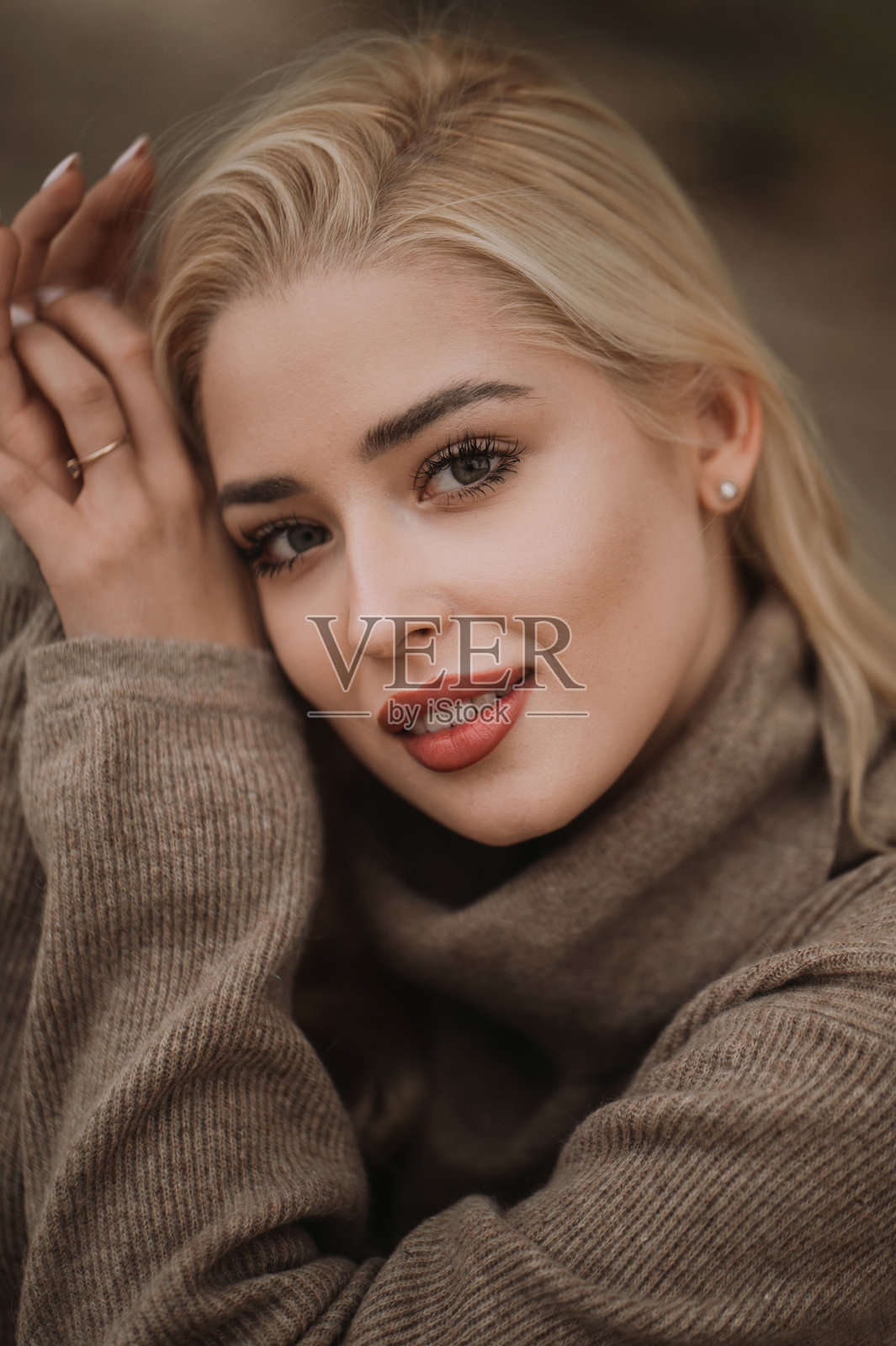 一位女士在阳光明媚的秋日，戴着时尚的帽子，穿着外套在户外散步。照片摄影图片