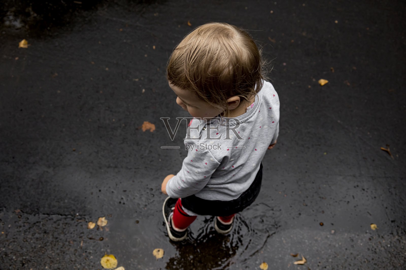 雨后站在水坑里的幼儿照片摄影图片