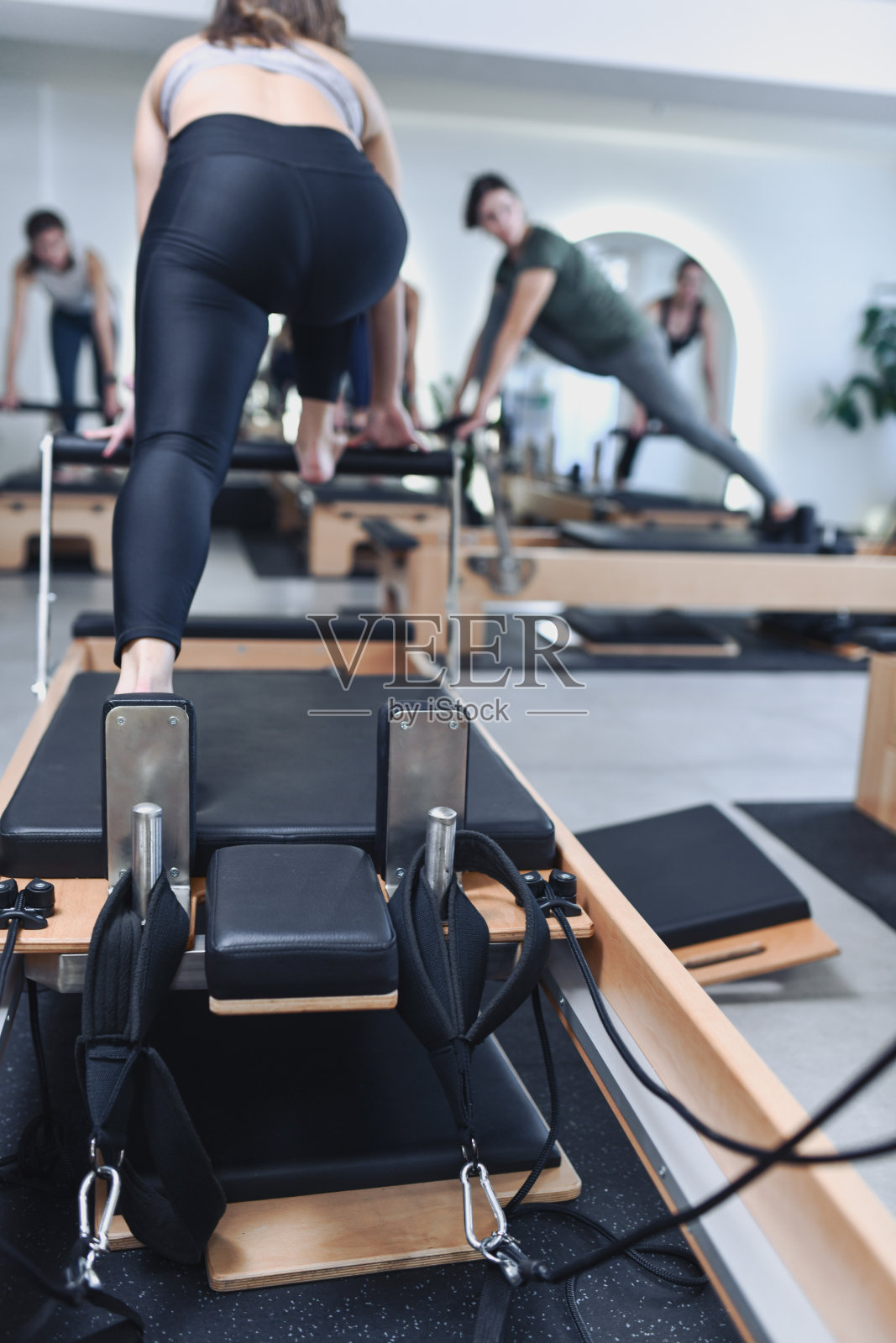 女性运动员使用普拉提器械进行伸展和核心训练照片摄影图片