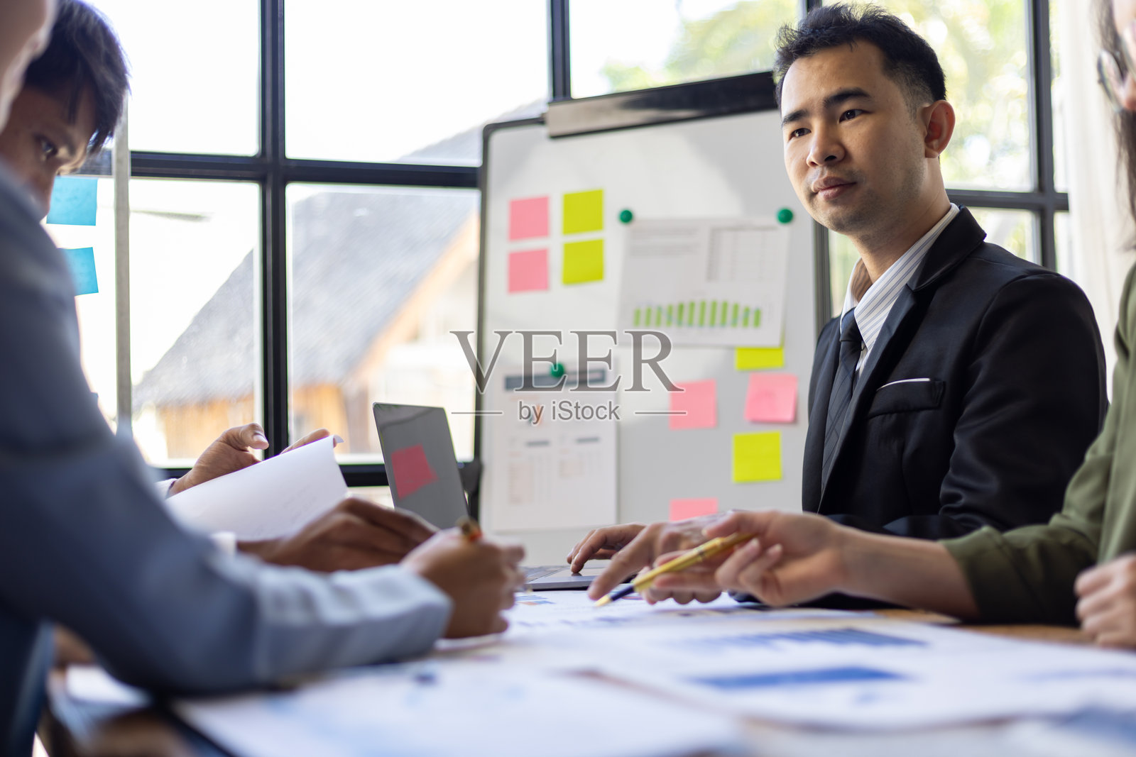 商务团队在办公室会议中分析数据并讨论财务策略，协作处理图表和报告以实现共同目标。照片摄影图片