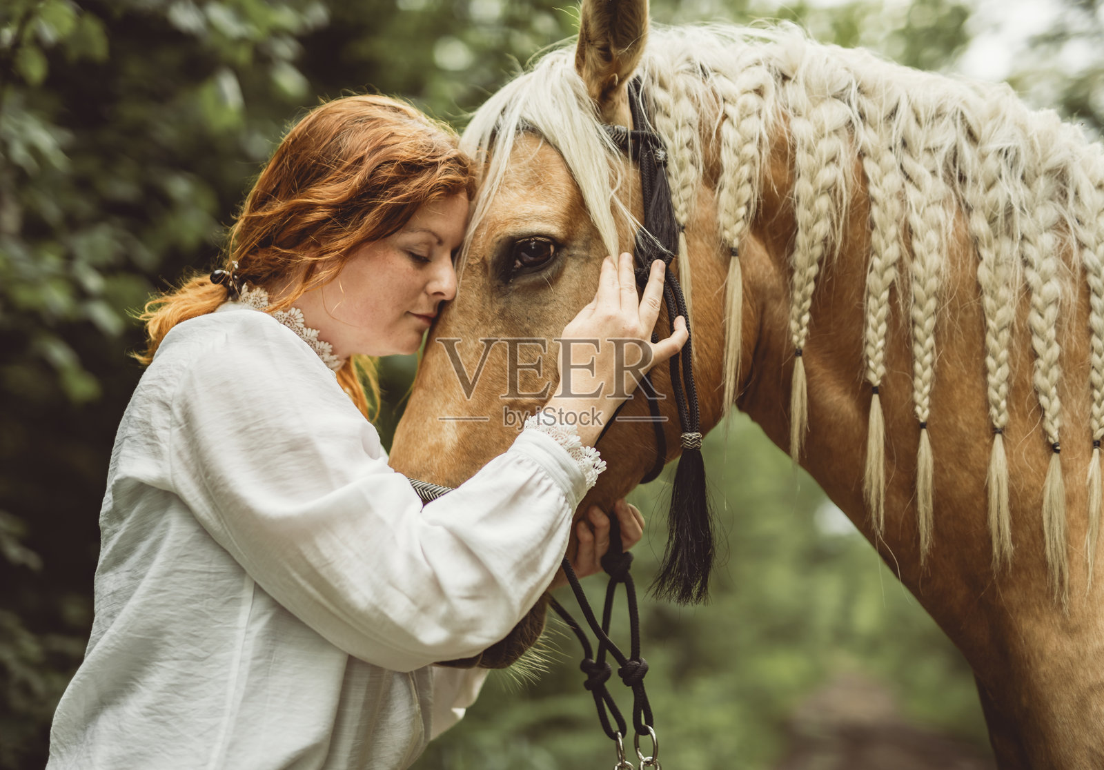 一位女士戴着牛仔帽在开阔的田野里骑马照片摄影图片