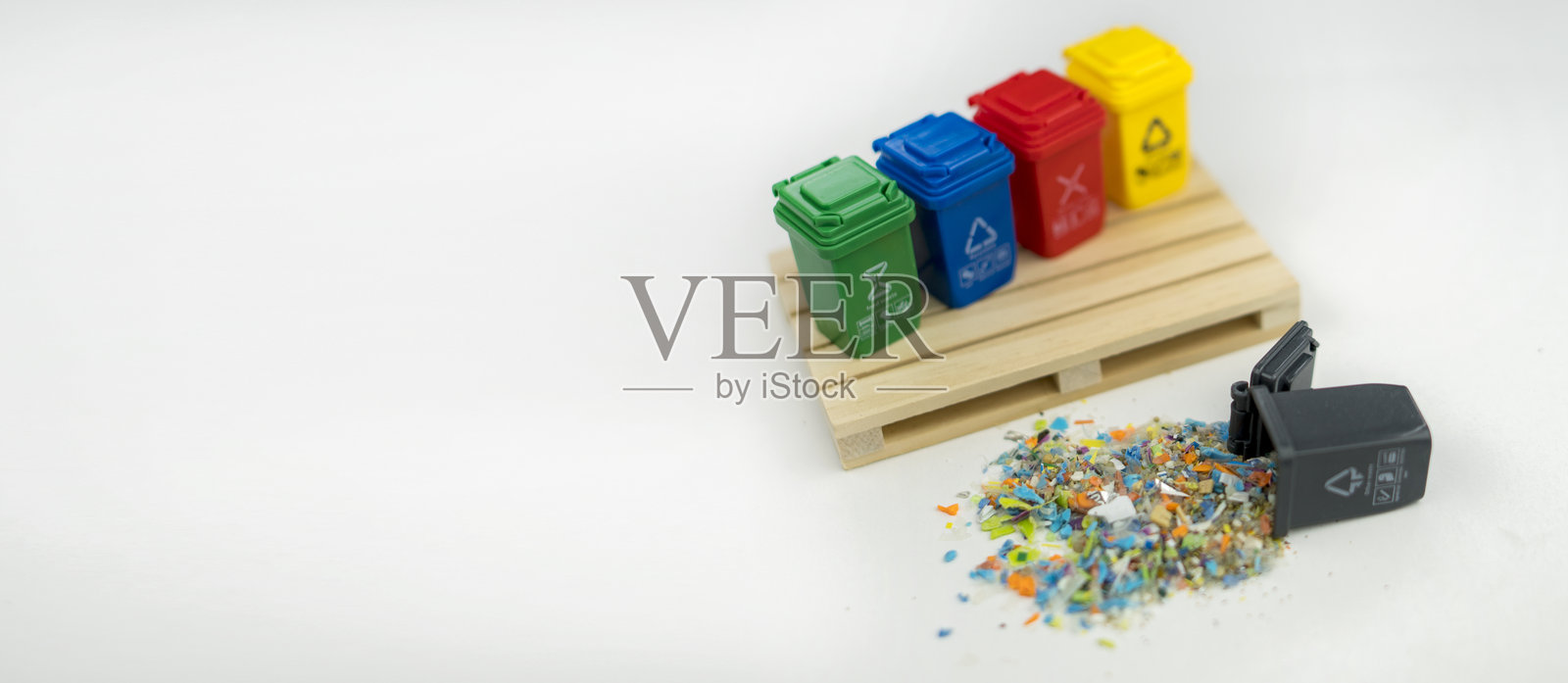 微塑料颗粒从小垃圾箱中溢出，象征着全球微塑料污染。照片摄影图片