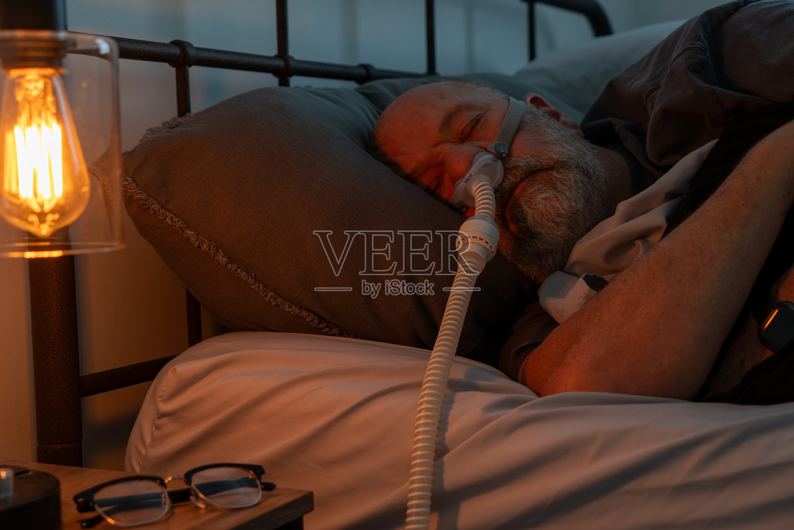 睡眠呼吸暂停治疗。夜间医疗设备支持。照片摄影图片