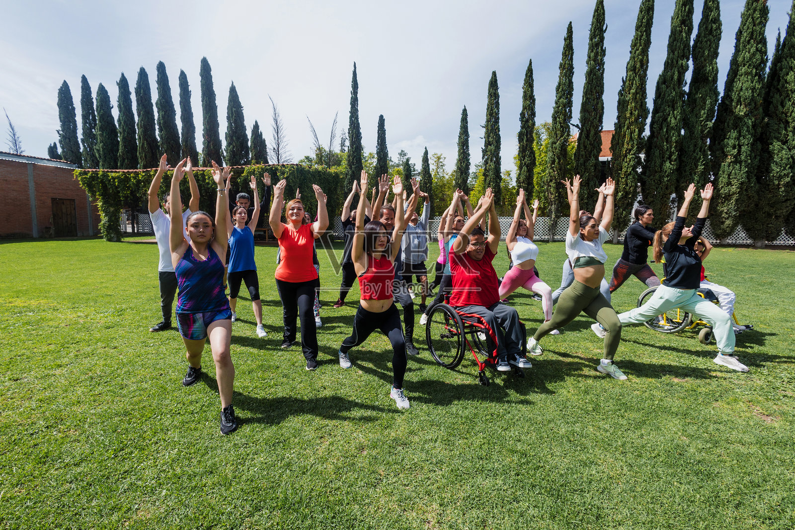 墨西哥拉丁美洲公共公园里，一群不同年龄的拉丁裔运动爱好者正在进行伸展运动，为健身课程或训练做准备，场面十分激动人心。照片摄影图片