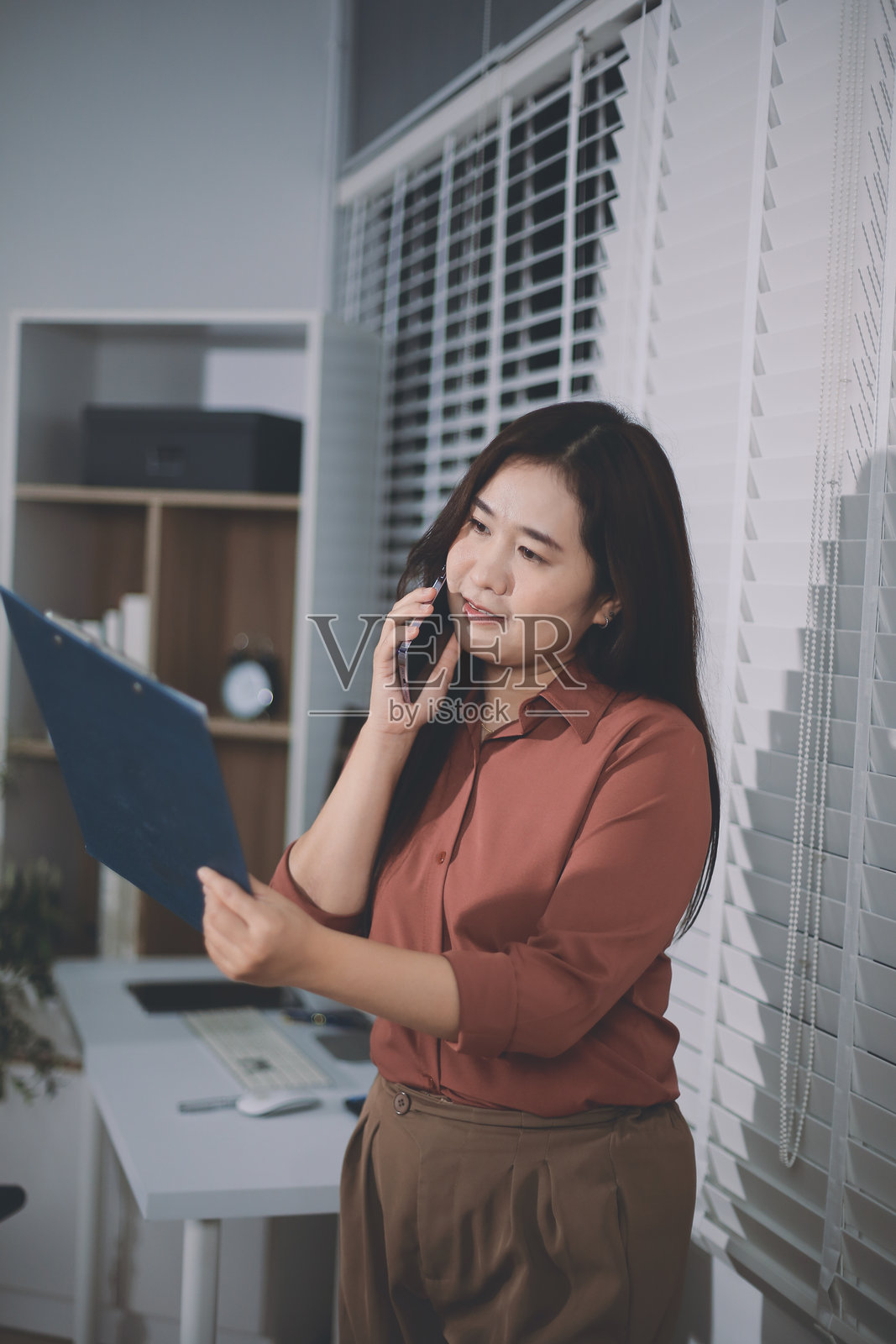 一位亚洲女性商务人士在网上查看邮件或社交媒体时使用手机，会计财务概念。照片摄影图片