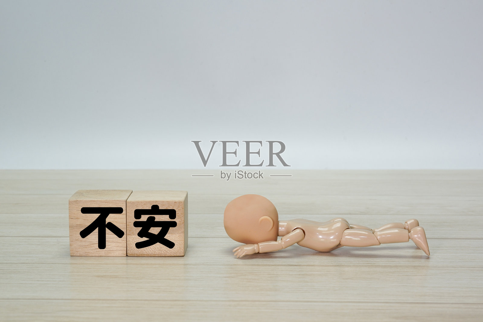 一个姿势颓废的玩偶，上面写着“焦虑”照片摄影图片