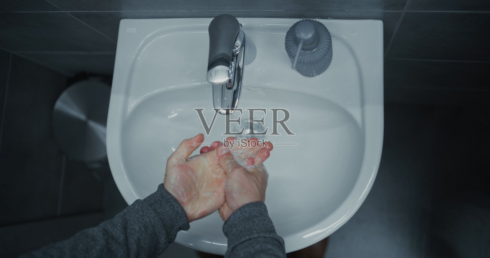 商务人士在现代办公室的洗手间里，在如厕后清洁洗手，注重手部卫生。照片摄影图片