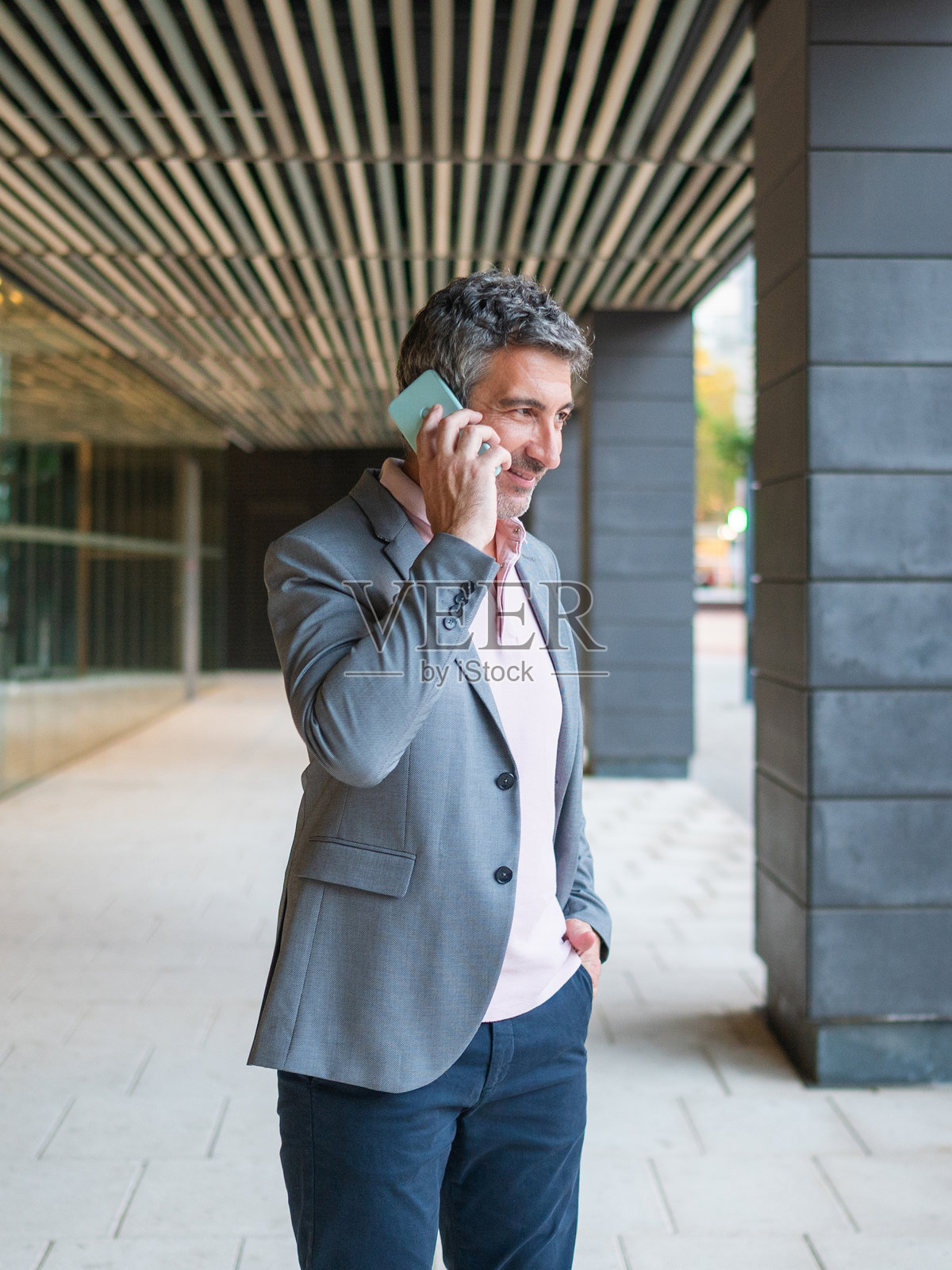 商人大笑地在户外用手机交谈照片摄影图片