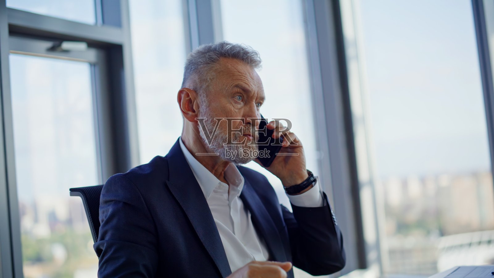 近距离特写：一位烦躁的首席执行官在工作场所对着智能手机大喊大叫，情绪激动地挥舞着手臂。照片摄影图片