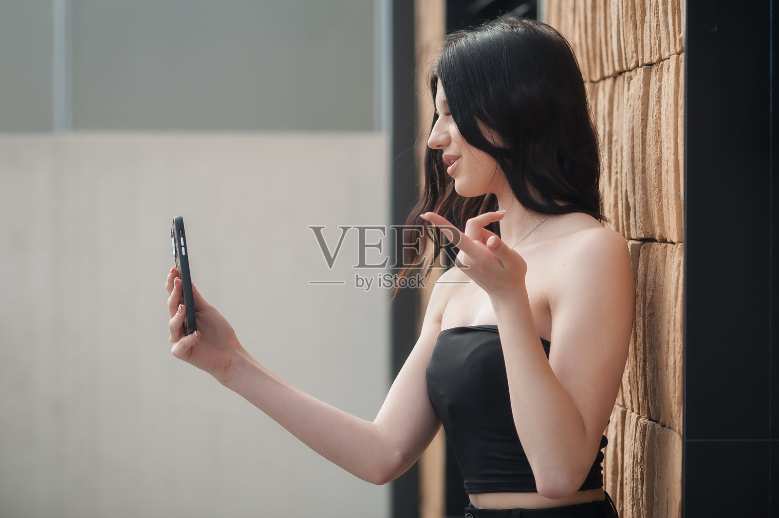 时尚的年轻女孩在明亮的日光下于现代都市地点自拍照片摄影图片