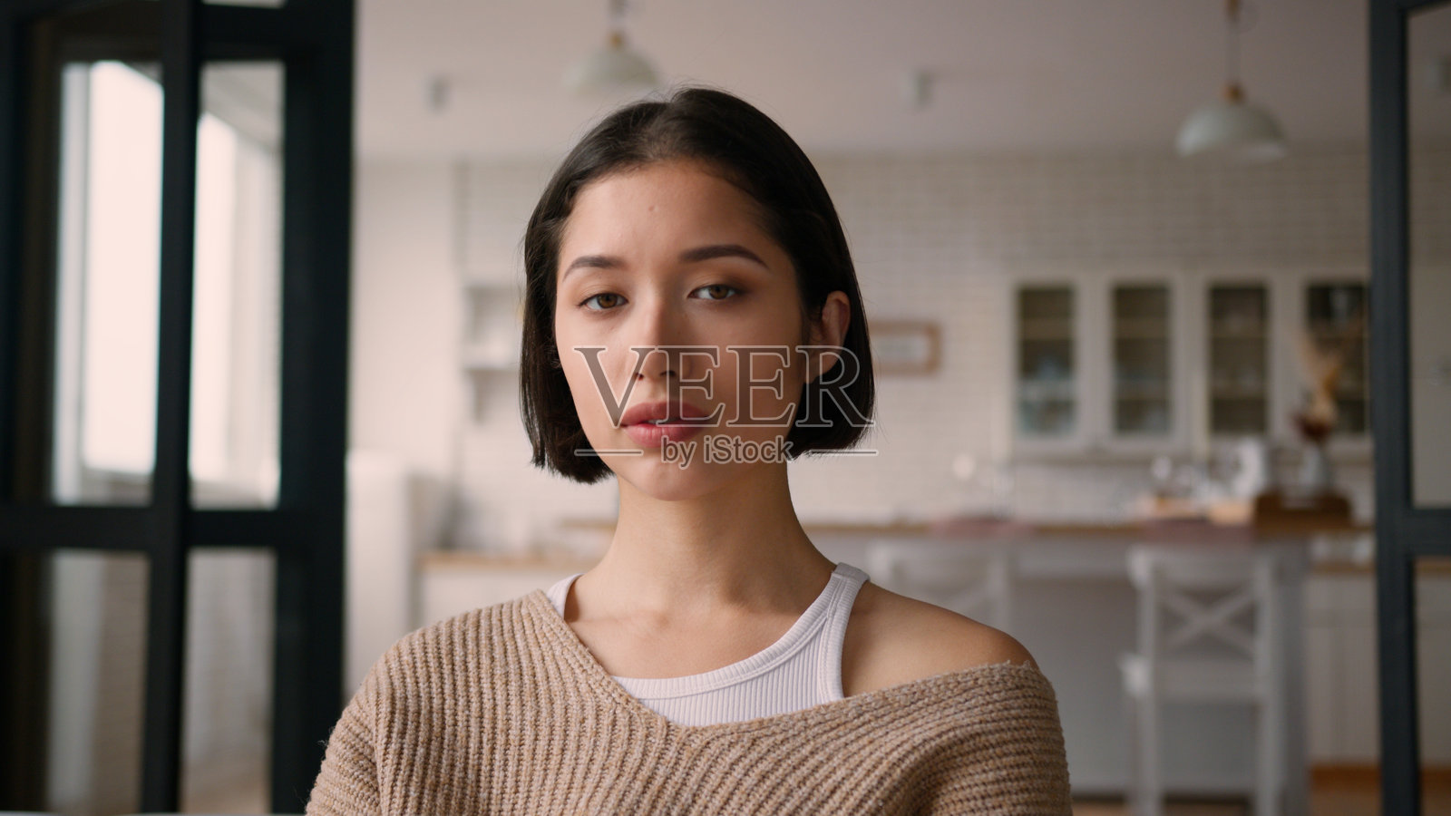 居家女性肖像，休闲的女孩、女士，冷静、严肃的西班牙裔/高加索裔家庭主妇，在家庭厨房里，房主、租客，沉思、认真地思考，转头看向镜头，房屋，信贷，抵押贷款照片摄影图片