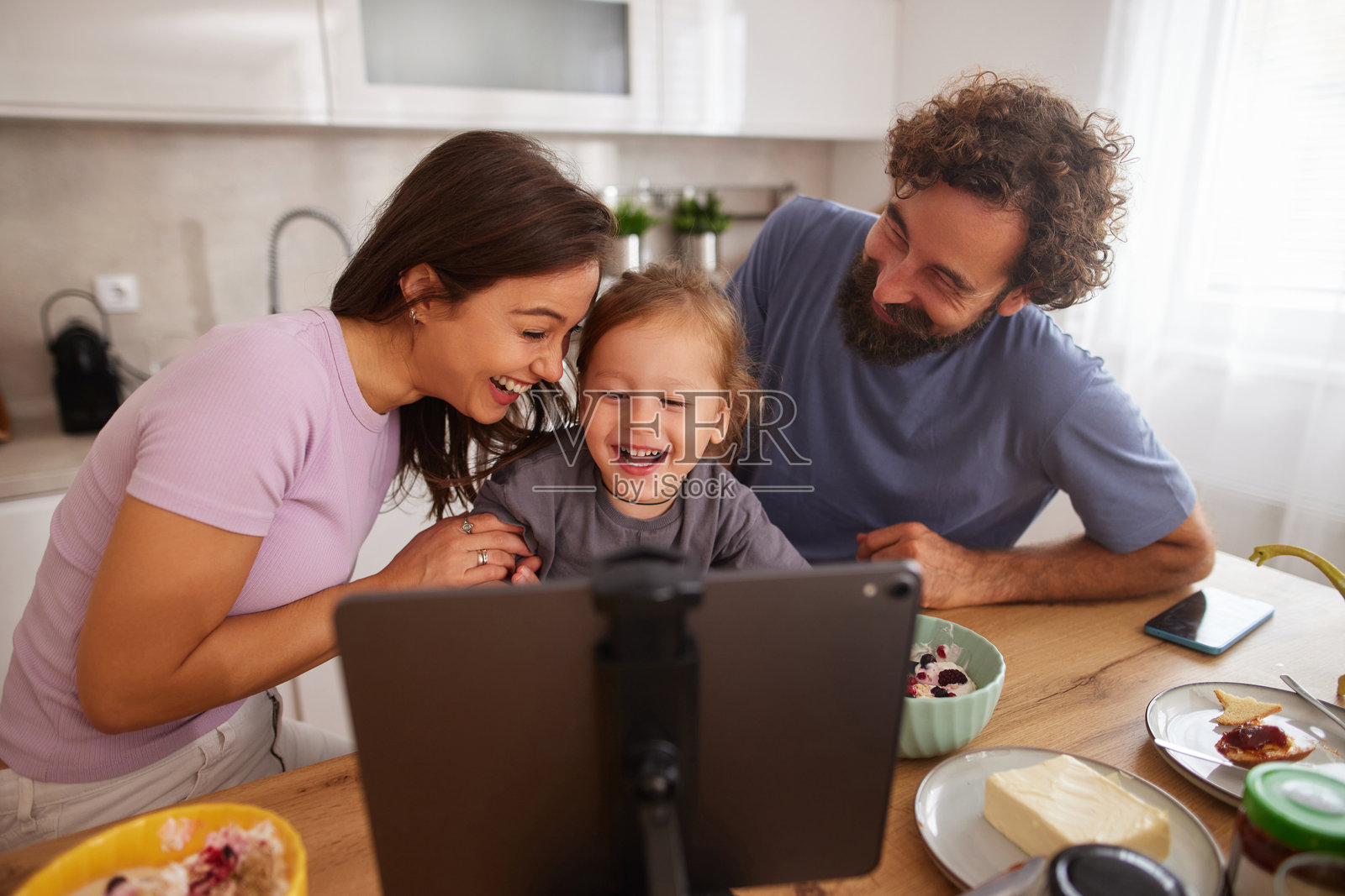 一家人开心地在家吃早餐时进行视频通话照片摄影图片