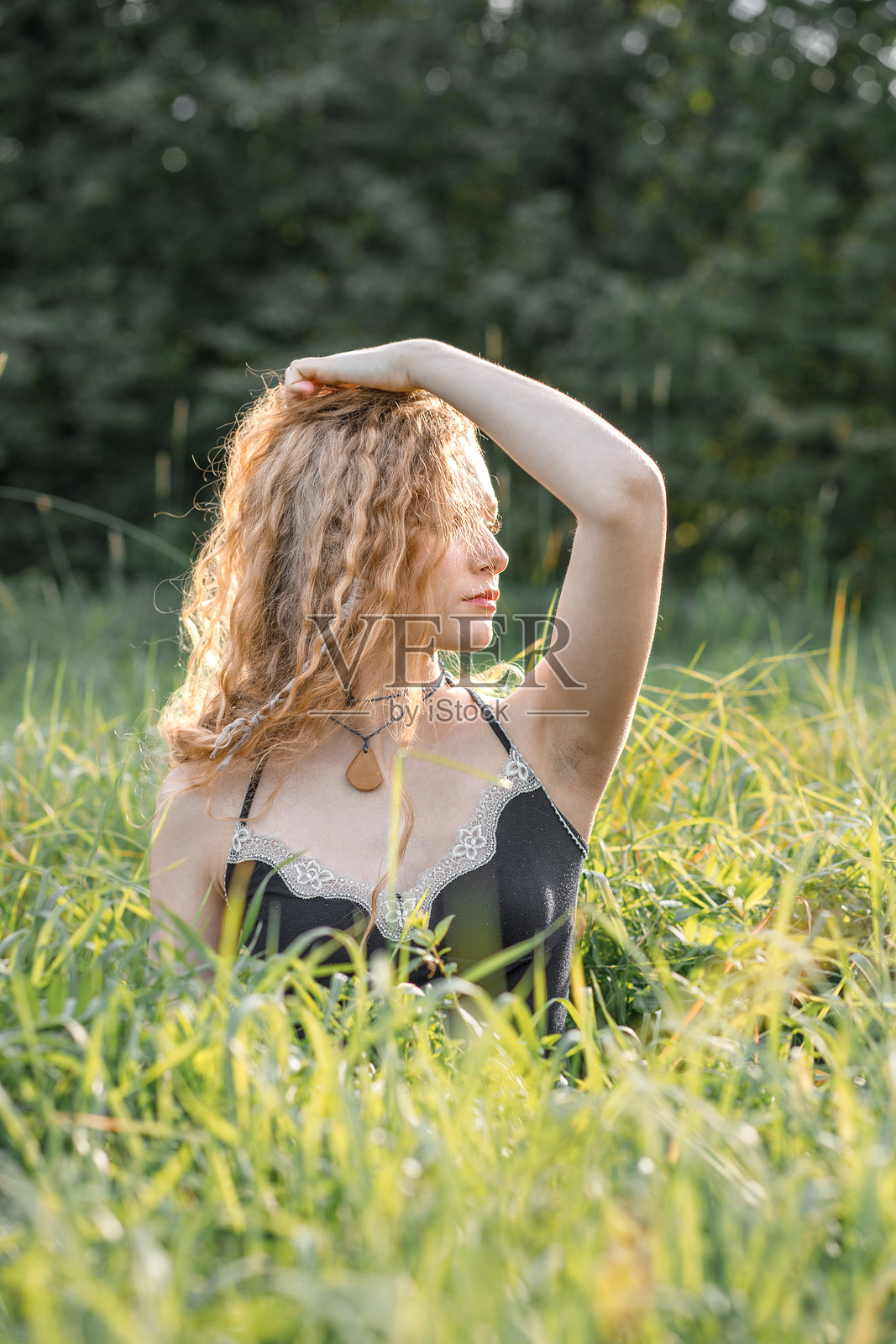 日落时分，时尚的嬉皮士年轻女性在自然背景下摆姿势拍照的肖像照照片摄影图片