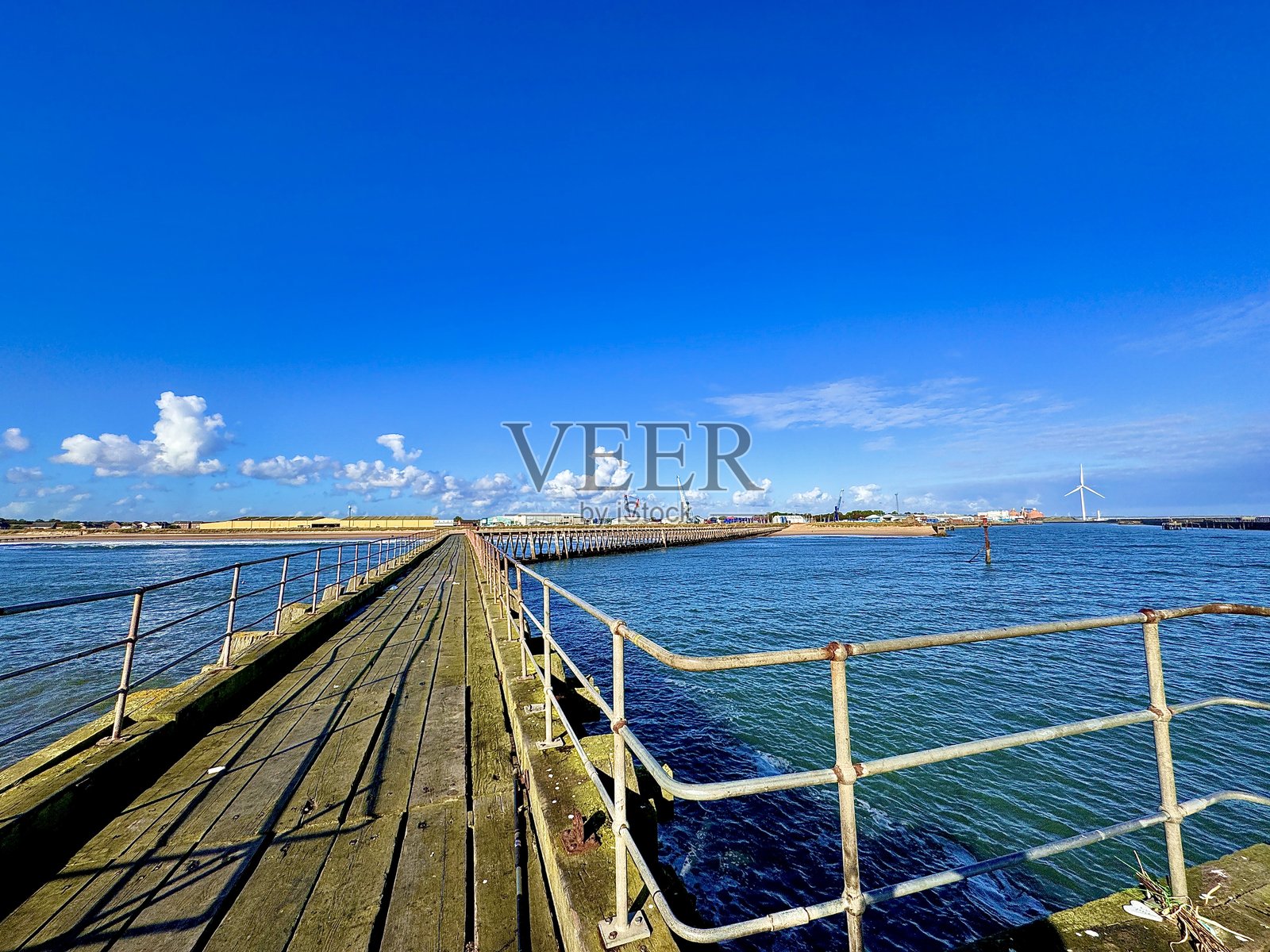 秋日清晨，从布莱思码头尽头望去，诺森伯兰郡布莱思港在云景的映衬下，依稀可见。照片摄影图片