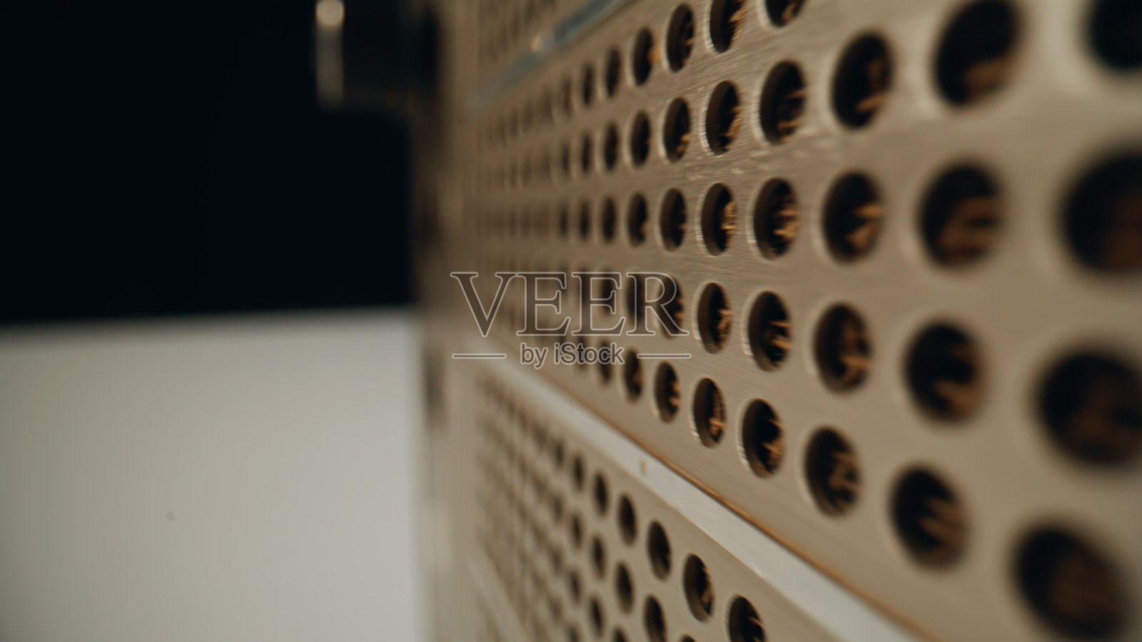 特写镜头：黑暗房间里发送音频信号的复古收音机正面。金属面板照片摄影图片