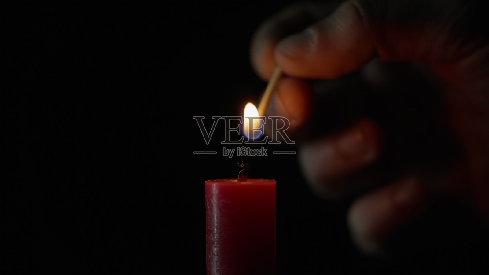 单支蜡烛的匹配灯光，在黑色背景上孤立。灯芯点燃火焰。照片摄影图片