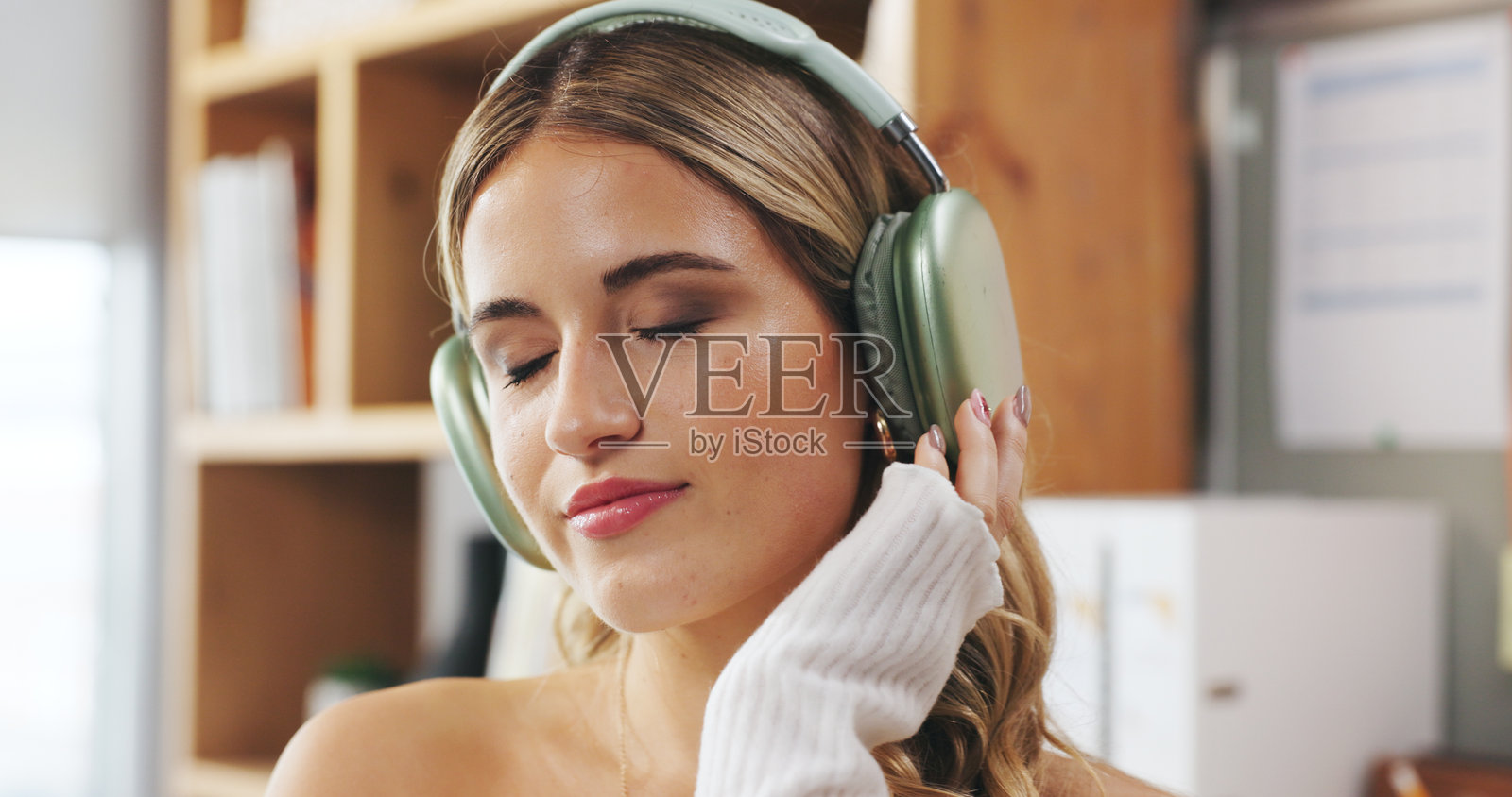 音乐、放松和远程工作，一位女性在家中办公室为小型企业或初创公司职业工作。休息、戴着耳机收听流媒体广播的自由职业者在公寓里放松，关注身心健康。照片摄影图片